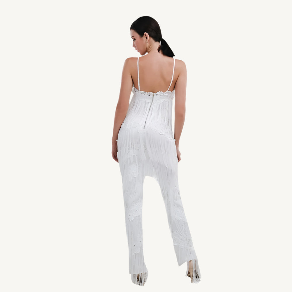 A chic white tassel jumpsuit with a flattering fit, featuring tassel details along the neckline and sleeves for a touch of playful elegance. The jumpsuit is perfect for both casual and semi-formal occasions, providing comfort without sacrificing style.