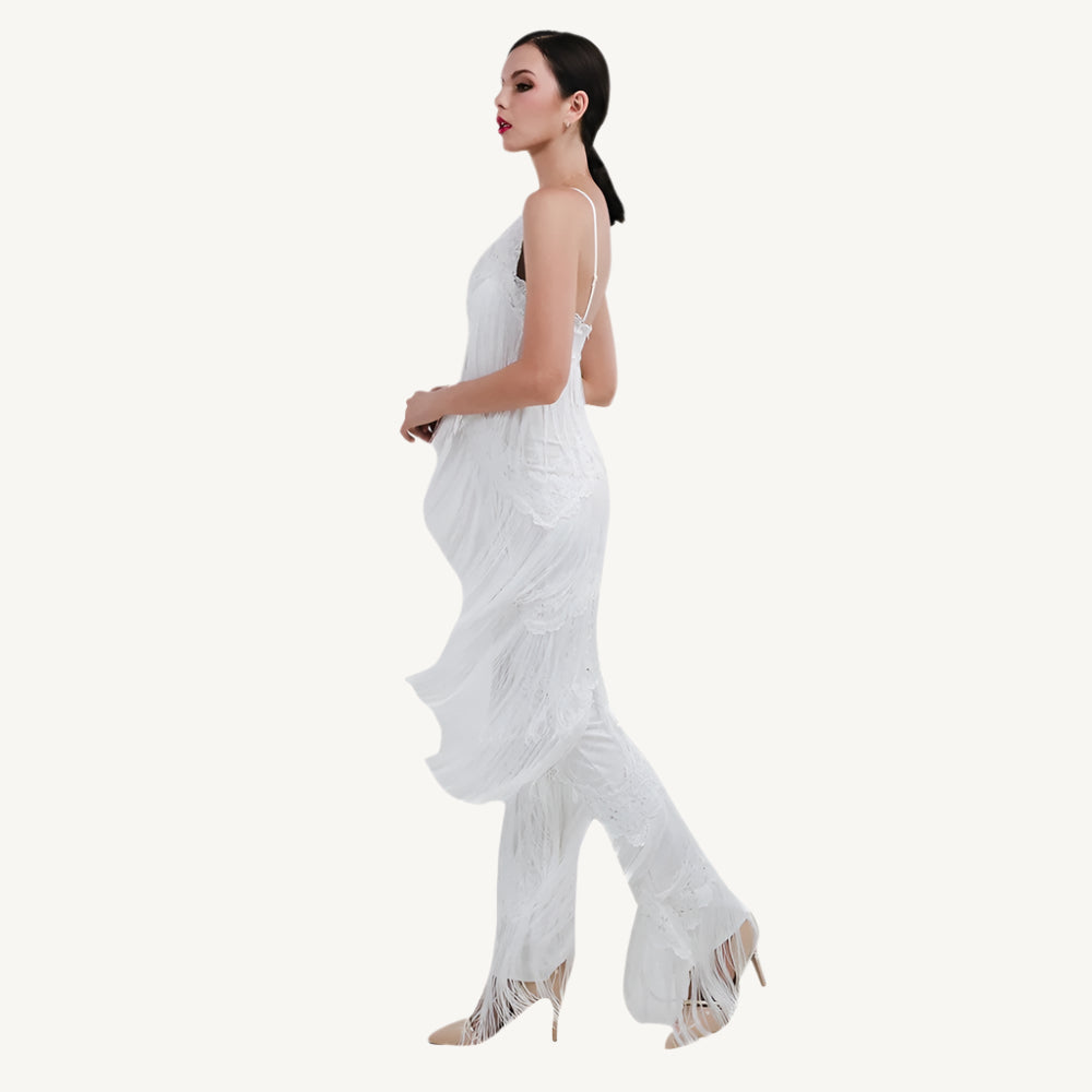 A chic white tassel jumpsuit with a flattering fit, featuring tassel details along the neckline and sleeves for a touch of playful elegance. The jumpsuit is perfect for both casual and semi-formal occasions, providing comfort without sacrificing style.